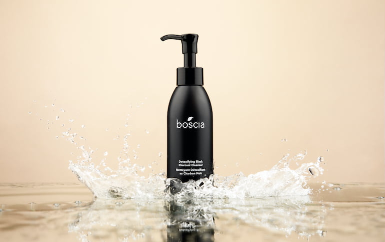 boscia Detoxifying Black Charcoal Cleanser for skin in a puddle of water